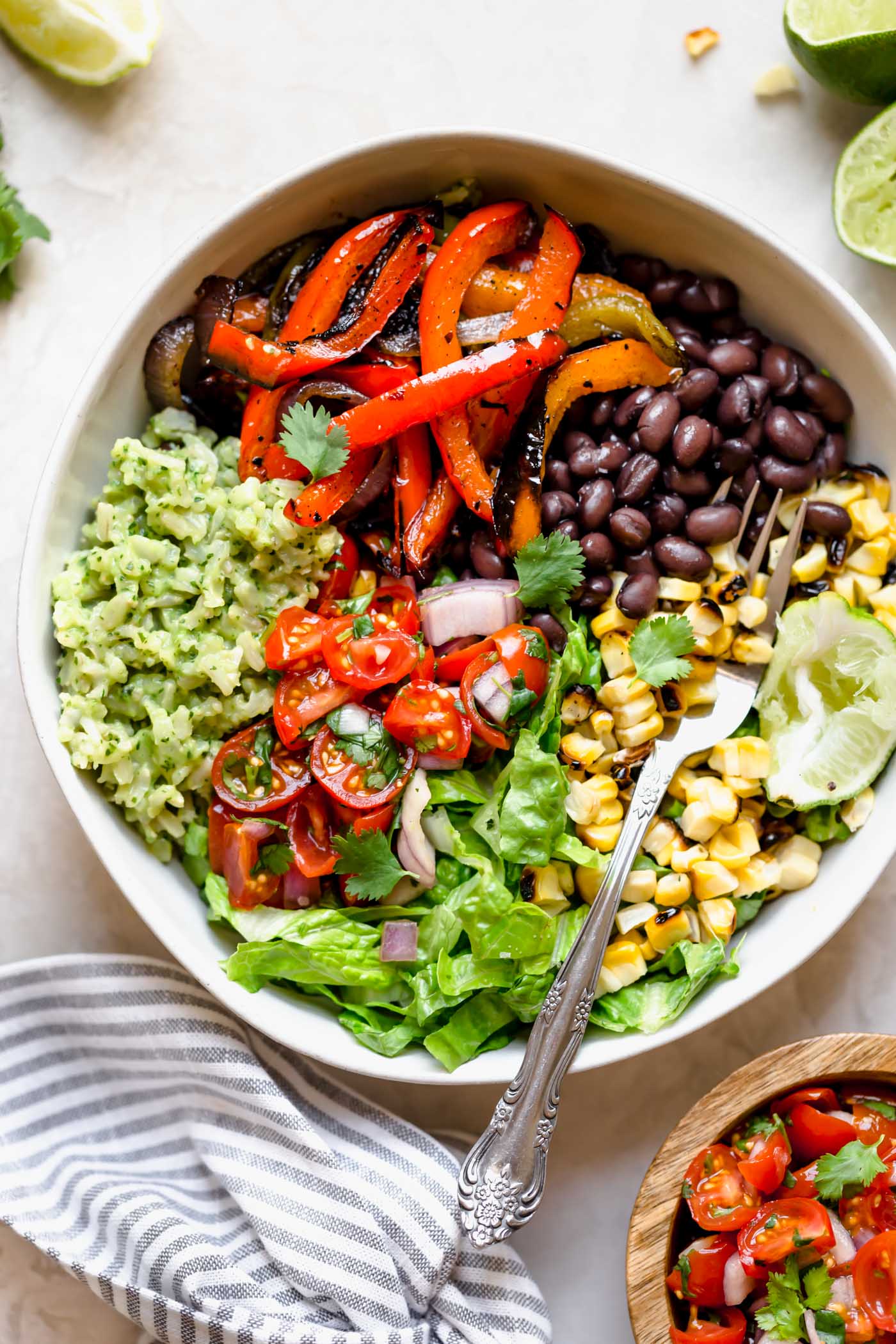 these easy & healthy grilled veggie burrito bowls are loaded with flavor! grilled peppers, onions, & sweet corn get paired with black beans & served with green rice - brown rice that’s tossed in a creamy avocado sauce. move over chipotle! wholesome, plant-based, naturally vegan & gluten-free, & meal prep-friendly! & #playswellwithbutter #veggieburritobowl #healthyburritobowlrecipe #easyrecipe #healthyrecipe #mealpreprecipe #grilledvegetables #greenrice #vegetarian #plantbased #vegan #easyvegandinnerrecipe #glutenfree #easyglutenfreereceipe
