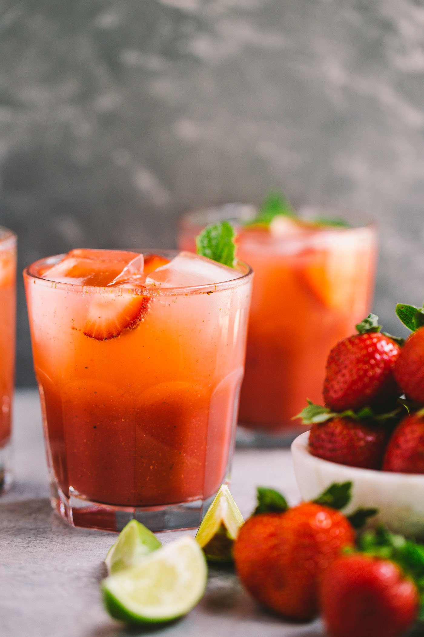 classic mojitos get a spicy strawberry twist in this easy cocktail recipe for spicy strawberry mojitos! fresh strawberries muddled with lime juice, mint, & spicy rum for the perfectly balanced spicy & sweet cocktails. these spicy strawberry mojitos will be your new favorite! #mojitos #easycocktail #cocktailrecipe #strawberrymojitos #spicystrawberrymojitos #playswellwithbutter