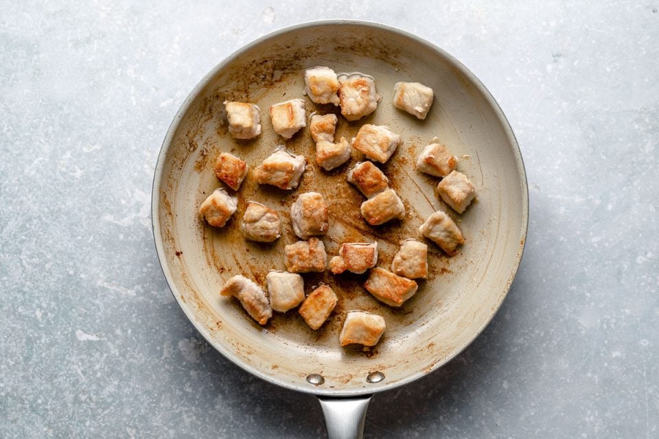 Browning lightly dredged cubed pork loin in a large skillet.